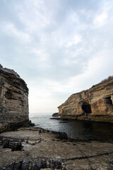 rock formations at seaside and colorful sunset with clouds