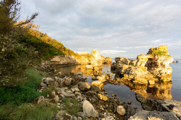 rock formations at seaside and colorful sunset with clouds