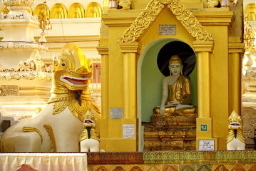 Buddha statue beside a lion statue in a temple in Rangon, Myanmar