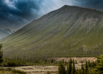 Rockies, forest, river under storm ladden skies Banff Windermer HWY Kootenay National Park British Columbia Canada