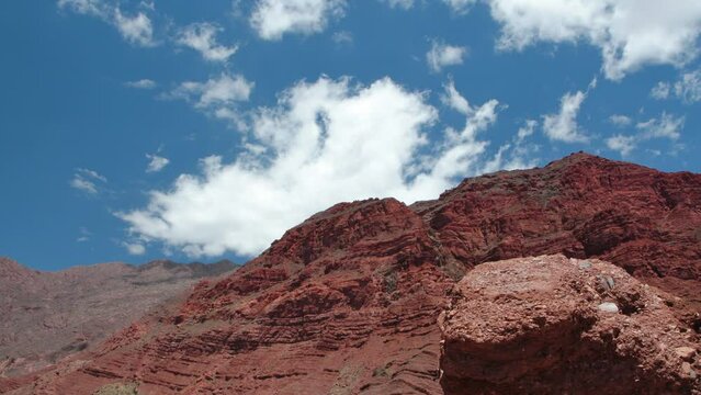 Time lapse in the red canyon. View of the desert, sandstone cliffs, mountains and white clouds passing by in Quebrada de las Conchas, Cafayate, Salta, Argentina. 