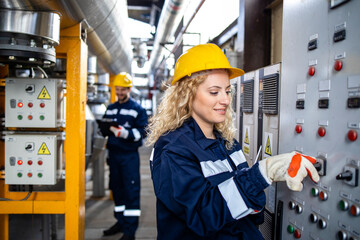 Female factory worker operating power station in oil and gas refinery.