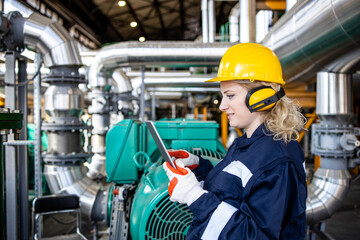 An experienced factory engineer checking production parameters of oil and gas production in...