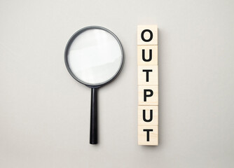 the wooden cubes with the word output and magnifier - obrazy, fototapety, plakaty
