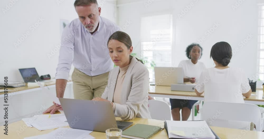 Aufkleber two business people discussing paperwork and looking at a laptop screen together. male manager mento