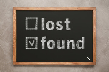 Words Lost and Found written on blackboard on grey background, top view