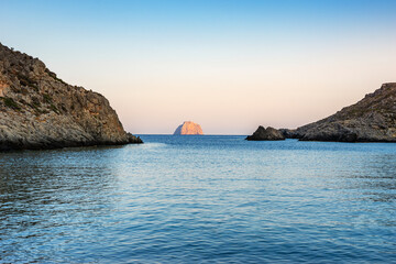 Fototapeta na wymiar View of the famous rocky beach Melidoni in Kythira island at sunset. Amazing scenery with crystal clear water and a small rocky gulf, Mediterranean sea, Greece, Europe.