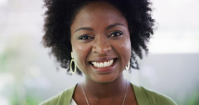 Closeup portrait of one confident african american woman showing a thumbs up while standing at home. Face of a pleased black female with an afro expressing satisfaction while making a hand gesture