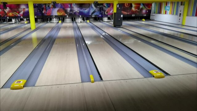 One woman throwing a bowling ball on the playing track.