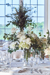 Luxury Beautiful Stylish Romantic Greens and Whites Fresh Flower decorations of guest tables at the wedding venue dinner celebration set up