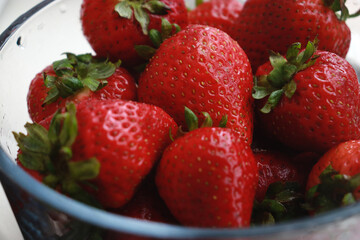 fresh strawberries in a bowl with water, upper view