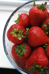 fresh strawberries in a bowl with water, upper view