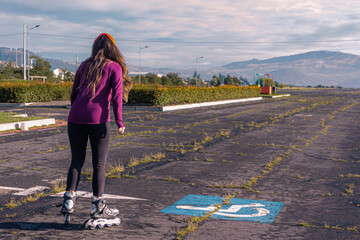young sporty woman practicing inline skating in an urban setting. Rolling skate in a sunny morning