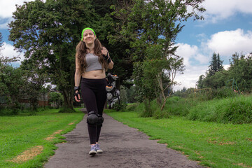 young sporty woman walking with line skates, ready to practice skating.