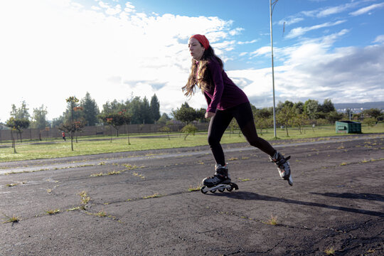 young sporty woman practicing inline skating in an urban setting. Rolling skate in a sunny morning