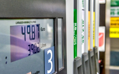 Gas prices at a petrol pump in a petrol station. Close up on fuel nozzle in oil dispenser with gasoline and diesel in service gas station.
