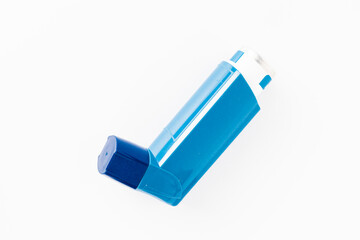 Blue asthma inhaler with blank label isolated on white background. Pharmaceutical product is used to treat or prevent asthma attack. Health and medical concept.