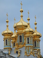 Fototapeta na wymiar The cross atop the golden-yellow dome of a Russian building.