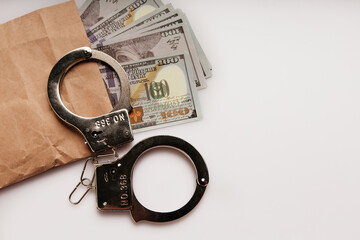 Envelope with dollars and handcuffs on a white background. Bribe and financial fraud concept