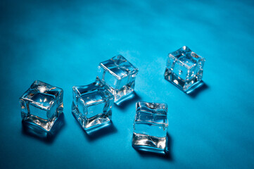 Clear ice cubes for cooling drinks on a blue background.