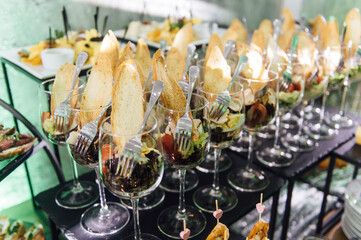 Large table with snacks of different types at a party with creative disco lighting.