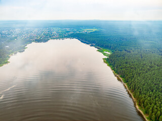 Big lake with green shores in bright sun light, aerial landscape. Recreation concept. Aerial view