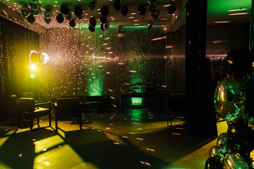 The disco ball mirror spins and reflects the light at the disco in the club.