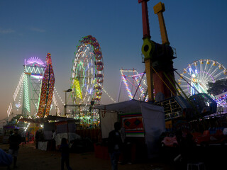 Giant wheel carnival ride or Ferris wheel flyer ride in indian village fair ground at night