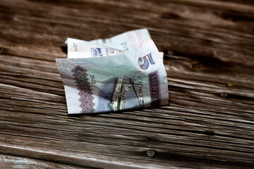 Folded Saudi Arabia money of 5 SAR five riyals isolated on wooden background, wrinkled 5 Saudi...