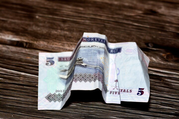 Crumpled Saudi Arabia money of 5 SAR five riyals isolated on wooden background, wrinkled 5 Saudi...