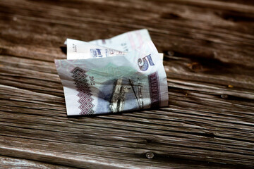 Folded Saudi Arabia money of 5 SAR five riyals isolated on wooden background, wrinkled 5 Saudi...