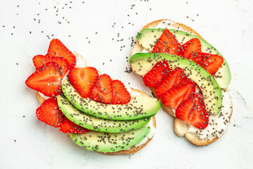 avocado toast with strawberries, soft cheese and chia seeds on a light background. healthy Breakfast or lunch. Keto diet. Food recipe background. Close up