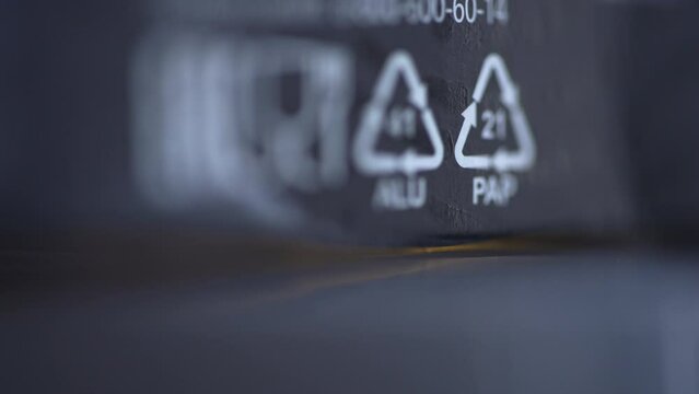 4k Closeup view of 41 alu, 21 pap and other recycle signs on black product packaging spbd. Drink cans and foil can be recycled. Boxes from household appliances, books, magazines, newspapers, packages