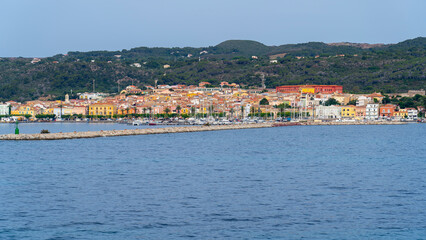 Fototapeta na wymiar Carloforte. Sardegna. Wonderful cityscape of the town from the boat that is approaching the island. Carloforte is the main city of the San Pietro island