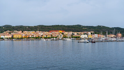 Naklejka na ściany i meble Carloforte. Sardegna. Wonderful cityscape of the town from the boat that is approaching the island. Carloforte is the main city of the San Pietro island
