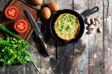 Egg breakfast food omelet has vegetable in pan on wood table. - obrazy, fototapety, plakaty