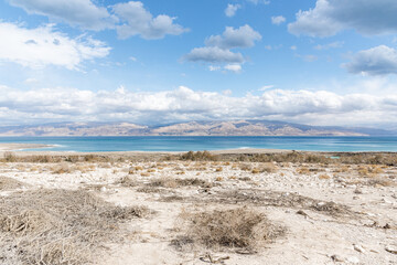 Exotic view of the sinkhole area of the Dead Sea on a stormy winter day. PhotoStorm and rain at the Dead Sea coastline. Salt crystals at sunset. The texture of the Dead sea. Salty seashore. High