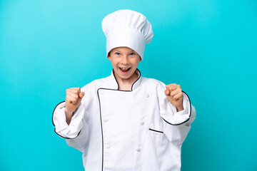 Little chef boy isolated on blue background celebrating a victory in winner position