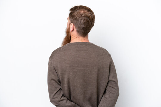 Redhead man with beard isolated on white background in back position and looking back