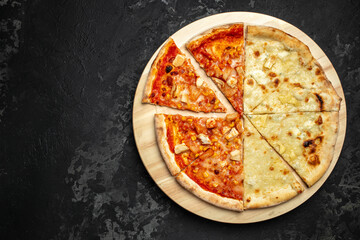 Tasty hawaiian pizza with chicken and pineapple pizza Four Cheeses on wooden cutting board on a dark background. food delivery, place for text, top view