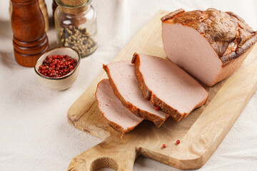 Traditional oven baked bavarian meal leberkäse sliced - meat dish made of corned beef, pork and bacon, finely ground and bakes as a bread loaf, on wooden board on beige colored table cloth - obrazy, fototapety, plakaty
