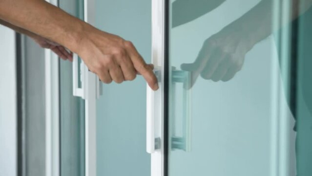Close-up of man's hand clossing a glass door with a key.