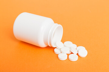 different drugs and health supplement pills poured from a medicine bottle health care and medical...