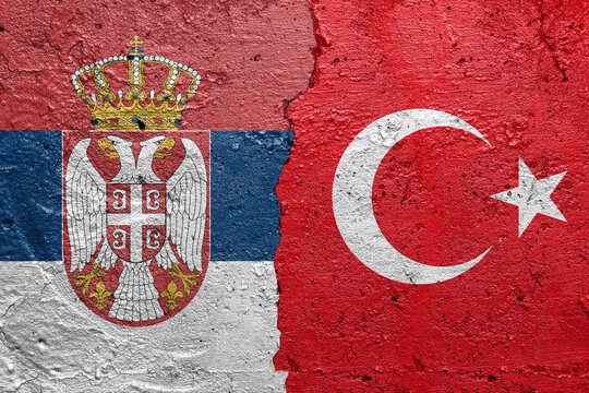Serbia and Turkey - Cracked concrete wall painted with a Serbian flag on the left and a Turkish flag on the right stock photo