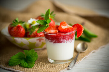 sweet homemade yogurt with strawberry jam and fresh strawberries in a glass cup