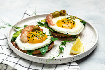 Toast with wholemeal bread, soft fried egg, spinach, avocado, shrimps on wtite background, Ketogenic breakfast. superfood concept. Healthy, clean eating. Top view