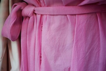 Ausschnitt von pinkem Sommerkleid aus Baumwolle mit Gürtel 