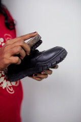 woman wiping her black shoes with a brush. High quality photo
