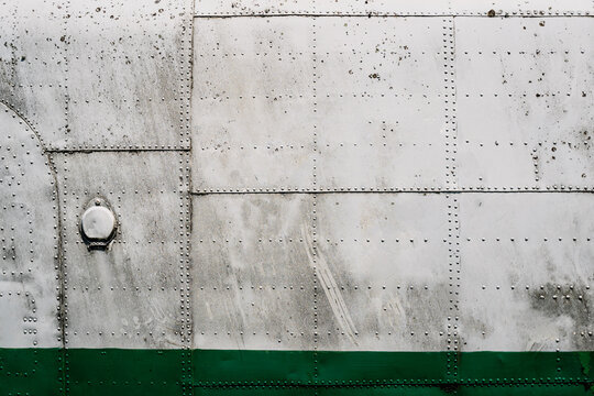 metal airplane hull plating with rows of rivets