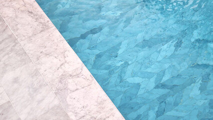 swimming pool background. part of swimming pool showing white carrara marble tile at pool side and...